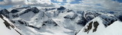 Z vrcholového hrebeňa Helvetestindu môžem v plnej kráse sledovať hory od Sjovdoly až po Gjuratinden, kadiaľ viedla trasa pôvodne zamýšľanej túry (možnosť prezretia fotky vo väčšom rozlíšení)
