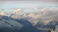 Ďaleko na východe sa vo svetle zapadajúceho slnka črtá skupinka kopcov nad najväčším alpským ľadovcom Aletschgletscher